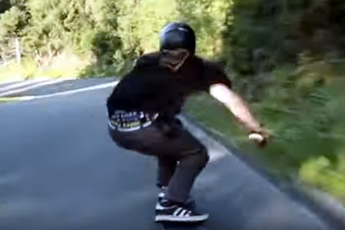 Jovem desce montanha em alta velocidade em skate 
