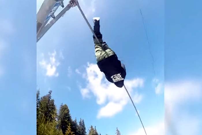 Jovem sobe em cabo de teleférico em estação de esqui 