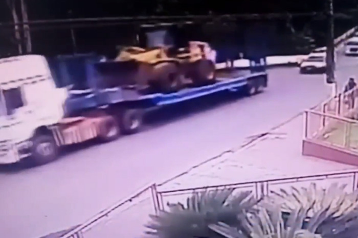 Trator cai do caminhão e quase atinge ambulância