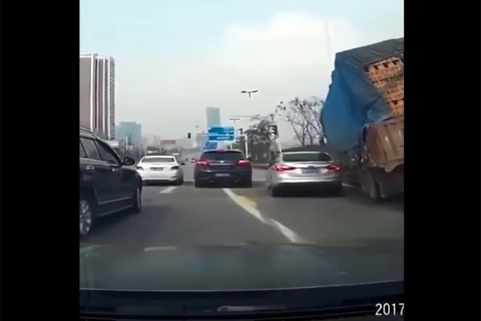 Caminhão carregado de tijolos tomba em cima de carro 