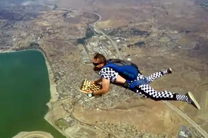 Paraquedista salta de avião e tenta manter peças em tabuleiro 