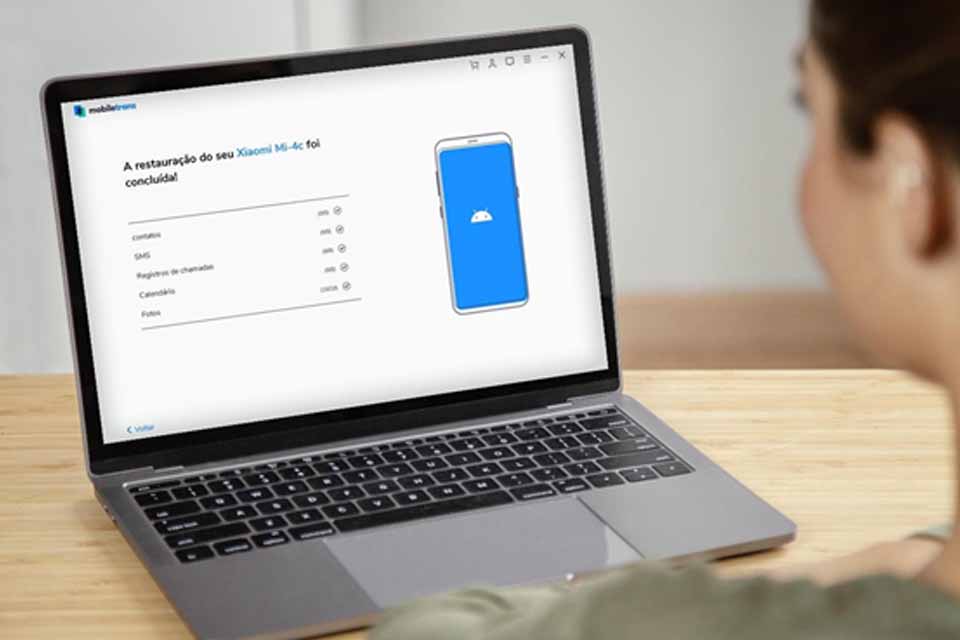 Pessoa na frente de um laptop aberto em cima da mesaDescrição gerada automaticamente